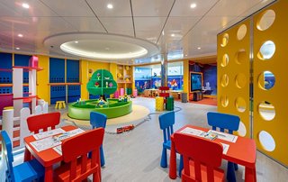 Ein farbenfroher und einladender Raum für Kinder mit roten und blauen Tischen und Stühlen | MSC Cruises