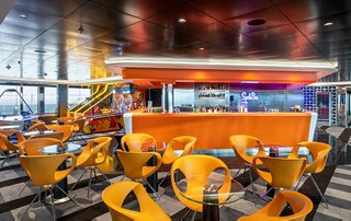 Ein lebendiger Sportbar mit orangen Sitzgelegenheiten, perfekt zum Entspannen und Genießen | MSC Cruises
