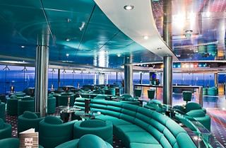 Una vibrante zona de entretenimiento con asientos modernos y decoración colorida crea una atmósfera acogedora para relajarse | MSC Cruceros