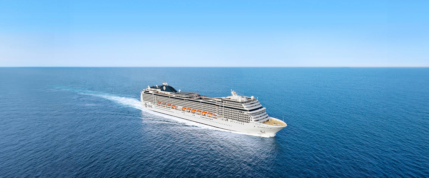 Cruise ship travels across a calm blue sea beneath a clear sky | MSC Cruises