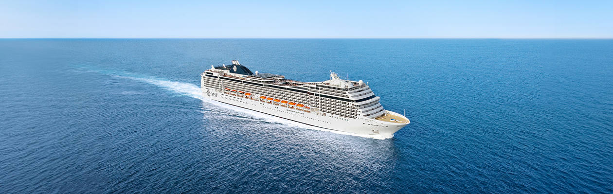 Cruise ship travels across a calm blue sea beneath a clear sky | MSC Cruises