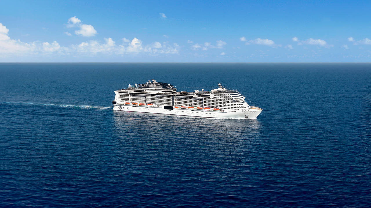 A majestic cruise ship gliding through the serene blue ocean under a clear sky | MSC Cruises