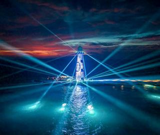 Vibrant nighttime light show surrounding the Ocean Cay lighthouse | MSC Cruises
