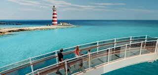 Bridge overlooking turquoise waters and a red lighthouse at Ocean Cay | MSC Cruises