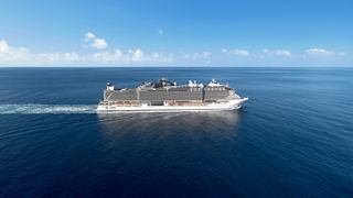 Ein majestätisches Kreuzfahrtschiff gleitet sanft über ruhige Gewässer unter einem klaren blauen Himmel | MSC Cruises