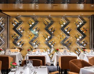 Elegant restaurant with beautifully set tables and a gold-accented wall | MSC Cruises