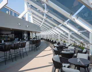 Bar soleado con vistas al mar y mesas elegantes | MSC Cruceros