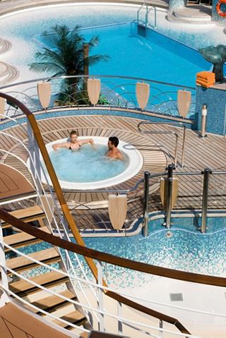 Un couple profite d'un moment de détente dans le bain à remous à côté de la piscine animée à bord de MSC Musica | MSC Croisières