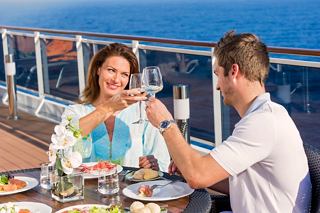 A couple enjoys a joyful lunch together on the deck of MSC Preziosa, celebrating moments with a toast | MSC Cruises