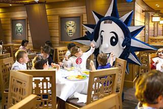 Kinder genießen ein lebhaftes Dining-Erlebnis mit einem Maskottchen in einem Restaurant auf der MSC Preziosa | MSC Cruises