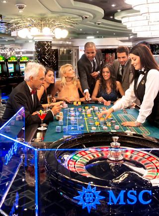 Friends enjoying an exciting game of roulette at the casino on MSC Divina with a friendly dealer | MSC Cruises