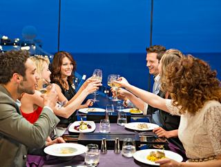 Un grupo alegre de amigos brinda juntos durante la cena en el Galaxy Lounge de MSC Preziosa | MSC Cruceros