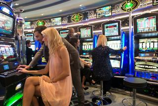 Friends enjoying a lively moment at the Casino Veneziano on MSC Divina, surrounded by vibrant slot machines | MSC Cruises