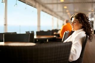 A guest enjoying a drink while relaxing at a bar by the covered pool on MSC Splendida | MSC Cruises