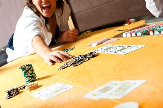 A woman enjoys playing cards at a vibrant casino table on MSC Splendida | MSC Cruises