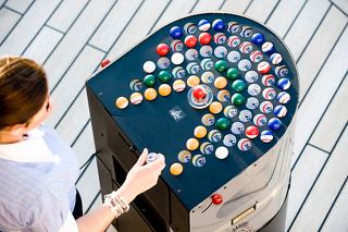 Guests enjoying a game of bingo on the deck of MSC Splendida, surrounded by vibrant game pieces and staff support | MSC Cruises