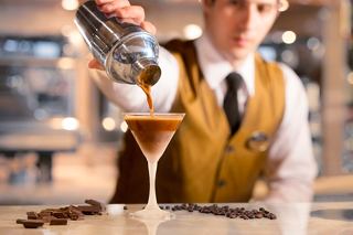 A skilled bartender expertly pours a cocktail into a glass at the bar on MSC Preziosa | MSC Cruises