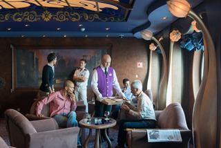 A group of friends enjoys drinks together in a stylish bar on MSC Divina with attentive staff members | MSC Cruises