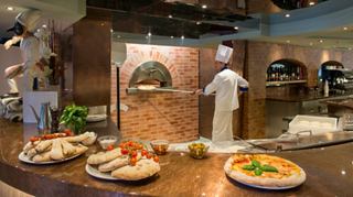 A chef prepares delicious pizzas at La Cantina Di Bacco, showcasing culinary expertise and inviting flavours | MSC Cruises