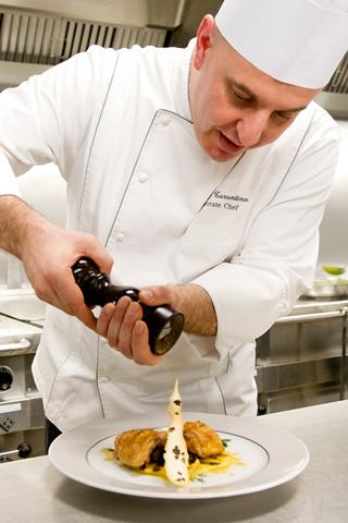 A chef artfully garnishing a gourmet dish in the kitchen, showcasing culinary expertise and passion for food | MSC Cruises