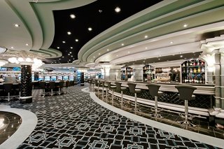 A spacious and stylish casino area with elegant seating and a bar counter onboard MSC Divina | MSC Cruises