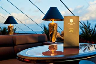 A beautifully set table in the Top Sail Lounge of MSC Divina, featuring a menu and elegant lamps | MSC Cruises