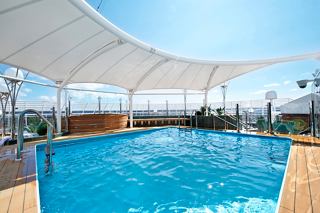 Une magnifique piscine extérieure au MSC Yacht Club sur le MSC Divina, invitant à la détente et au plaisir | MSC Croisières