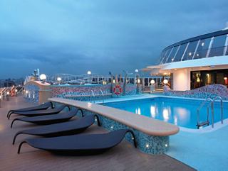 Una escena serena junto a la piscina en la cubierta del MSC Fantasia, invitando a la relajación bajo el cielo nocturno | MSC Cruceros