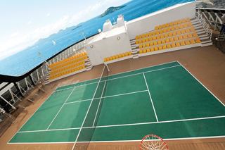 A tennis court on the deck of MSC Fantasia surrounded by blue sky and ocean | MSC Cruises