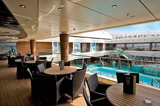 Relaxing dining area by the pool with tables and chairs, inviting guests to enjoy their meal and the view | MSC Cruises