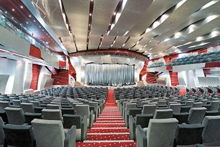Un teatro espacioso con filas de asientos y un escenario vibrante diseñado para el entretenimiento a bordo del MSC Fantasia | MSC Cruceros