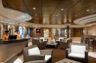 A relaxing lounge area with comfortable armchairs and a welcoming counter invites guests to unwind at MSC Aurea Spa | MSC Cruises