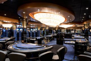 Un casino élégant avec des tables de jeux et un grand lustre, invitant les invités à une expérience passionnante | MSC Croisières