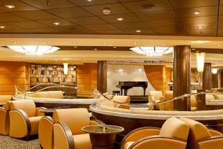 A warm and inviting bar area with stylish seating and a piano, perfect for relaxation and socialising | MSC Cruises