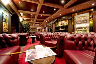 A welcoming interior of the Cuba Lounge Cigar Room with plush seating and elegant decor | MSC Cruises