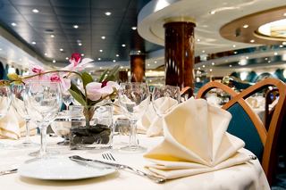 Ambiance chaleureuse au restaurant L'Edera sur MSC Magnifica avec des tables élégamment dressées et des fleurs | MSC Croisières