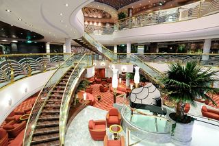 Un espace d'accueil spacieux avec un mobilier élégant et une végétation luxuriante accueille les invités à bord du MSC Magnifica | MSC Croisières