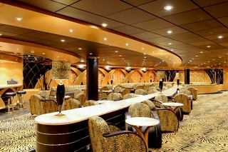A welcoming bar area featuring comfortable armchairs, tables, and soft lighting aboard MSC Magnifica | MSC Cruises