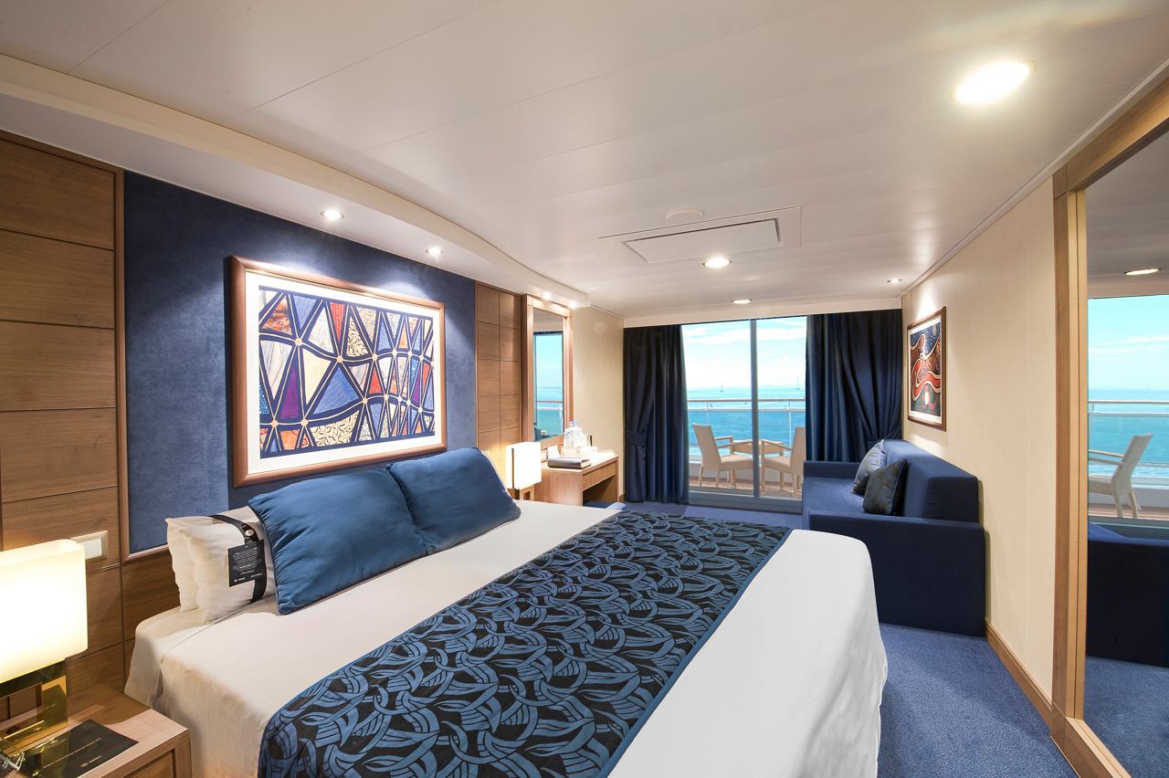 A stylish balcony cabin featuring a double bed, sofa, writing desk, and stunning views | MSC Cruises