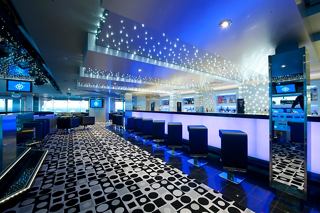 A vibrant disco bar with a stylish counter, footstools, and screens, inviting guests to enjoy entertainment | MSC Cruises