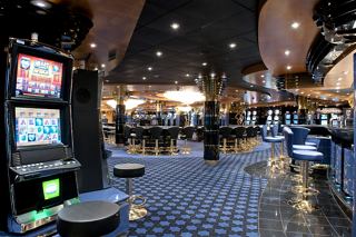 A lively casino area on MSC Magnifica featuring slot machines and a bar for entertainment | MSC Cruises