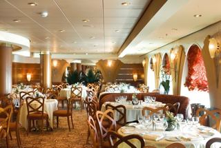A warm and inviting dining area in L'Oleandro Restaurant with elegant tables and chairs | MSC Cruises