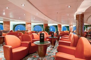 A warm and inviting lounge with comfortable seating and large windows overlooking the sea | MSC Cruises