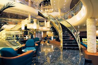 A welcoming reception area featuring elegant decor and a stunning staircase on MSC Musica | MSC Cruises
