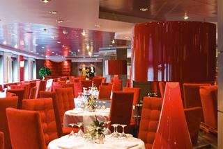 A vibrant dining area with red chairs and elegant tables, inviting guests to enjoy memorable meals together | MSC Cruises