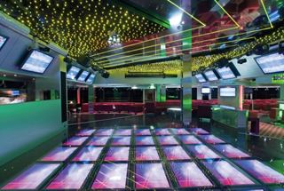 A vibrant, modern disco area on MSC Musica featuring a dance floor and comfortable seating for entertainment | MSC Cruises