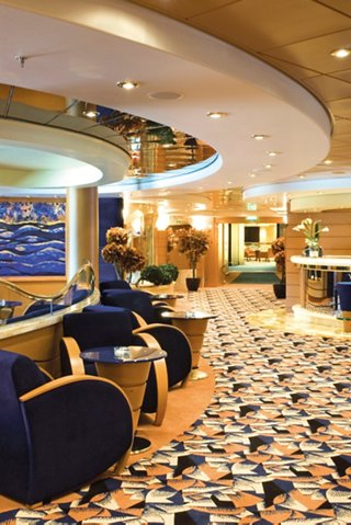 A welcoming lounge area featuring comfortable armchairs and tables at the Blue Velvet Bar on MSC Musica | MSC Cruises