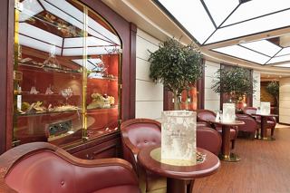 A warm and inviting view of L'Enoteca Wine Bar on MSC Musica, featuring comfortable seating and greenery | MSC Cruises