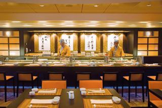A welcoming view of the Kaito Sushi Bar with staff ready to serve guests in a stylish restaurant setting | MSC Cruises