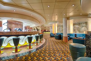 A welcoming lounge area featuring a stylish bar layout with seating options for guests to relax and enjoy | MSC Cruises